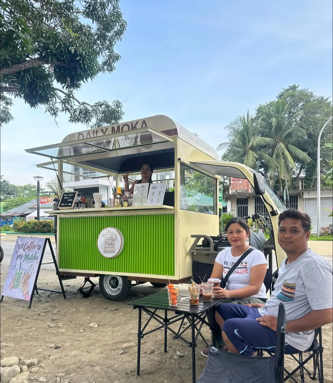 Two guests seated beside the Daily Moka cart with drinks on their table
